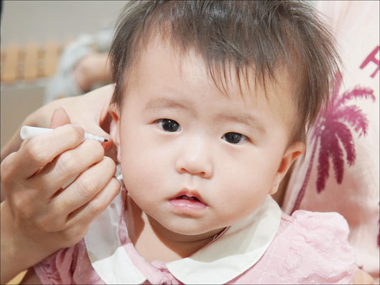 Toddler experiencing a painless ear piercing at Stellar Malaysia with professional care